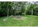 Wide backyard featuring a potential fire pit area, surrounded by mature trees and greenery at 4903 E Naomi St, Indianapolis, IN 46203