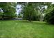 Large backyard with a green lawn and mature trees, offering ample space at 4903 E Naomi St, Indianapolis, IN 46203