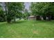 Expansive backyard with lush lawn, storage shed, bordered with mature shade trees at 4903 E Naomi St, Indianapolis, IN 46203