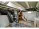 Unfinished basement boasts exposed ductwork and utilities, with potential for storage or future improvements at 4903 E Naomi St, Indianapolis, IN 46203