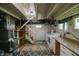 Unfinished basement features exposed ductwork, laundry area with washer/dryer, and stairs to the upper level at 4903 E Naomi St, Indianapolis, IN 46203