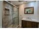 Bathroom with updated vanity, natural stone enclosed shower, and modern finishes at 4903 E Naomi St, Indianapolis, IN 46203