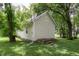 Side view of a charming home surrounded by lush greenery and mature trees, showcasing its peaceful setting at 4903 E Naomi St, Indianapolis, IN 46203