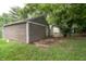 Detached garage with olive green siding offers parking and storage space in the property's backyard at 4903 E Naomi St, Indianapolis, IN 46203