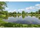 Scenic view of a calm pond reflecting trees and sky on a sunny day at 5152 Coppertree Ln, Avon, IN 46123
