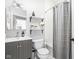 Well-lit bathroom with a vanity, mirror, open shelves, and tiled shower-tub combination at 519 Sutherland Ave, Indianapolis, IN 46205