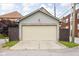 Exterior shot of detached garage with neutral door and siding, enhanced by a dark wood fence and mature tree at 519 Sutherland Ave, Indianapolis, IN 46205