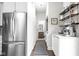 Hallway featuring stainless refrigerator, laundry, coffee bar, and doorway to half bathroom at 519 Sutherland Ave, Indianapolis, IN 46205