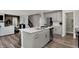 Kitchen island with stainless steel appliances and fixtures, open to the living room with fireplace at 5343 Pelion Pl, McCordsville, IN 46055