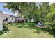 A spacious backyard featuring a well-maintained lawn, mature trees, and an outdoor seating area. Deck is in background at 5363 Primrose Ave, Indianapolis, IN 46220