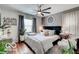 Comfortable bedroom with a decorative fan, accent wall decor, and hardwood floors at 5363 Primrose Ave, Indianapolis, IN 46220