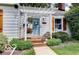 Charming front porch with a light blue door, shuttered windows, and delightful flower arrangements at 5363 Primrose Ave, Indianapolis, IN 46220
