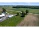 Aerial view showcasing a farmstead with a house, outbuildings, and cultivated fields at 5396 N 1000 E, Sheridan, IN 46069