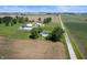 Aerial view of a farmhouse with outbuildings, set amidst expansive agricultural fields at 5396 N 1000 E, Sheridan, IN 46069