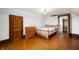Bright bedroom with hardwood floors, a wooden dresser, a bed frame, and a door at 5396 N 1000 E, Sheridan, IN 46069