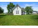 Quaint two-story white farmhouse with a green lawn and mature trees at 5396 N 1000 E, Sheridan, IN 46069