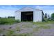 Spacious metal barn with gravel exterior and surrounding grass. Perfect for storage at 5396 N 1000 E, Sheridan, IN 46069