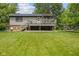 A full view of the spacious backyard featuring a deck, patio, and lush green lawn at 618 Shady Creek Dr, Greenwood, IN 46142