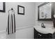 Elegant half-bathroom with a stylish black vanity, classic mirror, and neutral decor at 618 Shady Creek Dr, Greenwood, IN 46142