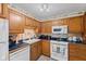 Efficient kitchen design features a dishwasher, white oven, and wood cabinetry at 618 Shady Creek Dr, Greenwood, IN 46142