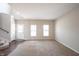 Comfortable living room with wood floors, plush carpet, abundant natural light from the windows, and a nearby staircase at 6218 N Woodside Ct, McCordsville, IN 46055