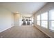 Bright living room featuring neutral walls, carpet, and an open-concept design leading to a well-lit kitchen at 6218 N Woodside Ct, McCordsville, IN 46055