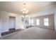 Spacious living room with carpet and hardwood floors, a chandelier, a staircase, and large bright windows at 6218 N Woodside Ct, McCordsville, IN 46055