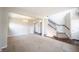 Open-concept living room with neutral walls, plush carpeting, and a staircase with wood banisters, creating a cozy atmosphere at 6218 N Woodside Ct, McCordsville, IN 46055