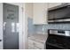 Pantry in the kitchen with storage and a glass-paneled door, located next to the stainless steel stove and microwave at 6218 N Woodside Ct, McCordsville, IN 46055