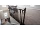 View from above of the carpeted staircase with dark wood railing leading to a bright lower level at 6218 N Woodside Ct, McCordsville, IN 46055