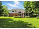 Wide shot of the backyard showing the home's elevated deck, screened-in porch, and mature trees at 6316 Harmonridge Ct, Indianapolis, IN 46278