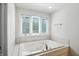 Relaxing bathroom features a jacuzzi tub and a large window for natural light at 6316 Harmonridge Ct, Indianapolis, IN 46278