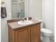 Cozy bathroom featuring a wooden vanity with sink, a framed mirror, and a toilet at 6316 Harmonridge Ct, Indianapolis, IN 46278