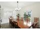 Bright dining room featuring a large wooden table, chandelier and view to the front yard at 6316 Harmonridge Ct, Indianapolis, IN 46278