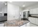 Open-concept kitchen with an island cooktop, white cabinetry, and an adjoining dining area at 6316 Harmonridge Ct, Indianapolis, IN 46278