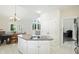 Bright kitchen with a central island with cooktop, a dining area with a chandelier, and access to the sunroom at 6316 Harmonridge Ct, Indianapolis, IN 46278