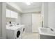 Functional laundry room with white washer and dryer, ample storage cabinets, and a utility sink at 6316 Harmonridge Ct, Indianapolis, IN 46278