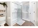 Bathroom with marble-look tiled shower, toilet, and adjacent jacuzzi bathtub at 6439 Bower Dr, Indianapolis, IN 46241