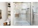 Bathroom with tiled walk-in shower, wooden bench, grab bars, and adjacent toilet at 6439 Bower Dr, Indianapolis, IN 46241