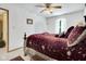 Bedroom showcasing a large wooden bed, ceiling fan, with a bedside table, bathed in natural light at 6439 Bower Dr, Indianapolis, IN 46241