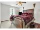 Bedroom with a large wooden bed and a ceiling fan, illuminated by natural light through the window at 6439 Bower Dr, Indianapolis, IN 46241