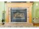Close-up of a brick fireplace with a wooden mantel and decorative accessories at 6439 Bower Dr, Indianapolis, IN 46241