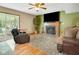 Cozy living room with fireplace, large television, and access to a sunroom at 6439 Bower Dr, Indianapolis, IN 46241
