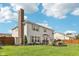 Sprawling backyard with lush lawn, patio area, and mature trees under a blue sky at 6622 W Dickens Xing, McCordsville, IN 46055