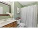 Cozy bathroom with stylish vanity, complemented by green walls, white shower curtain, and decorative mirror at 6622 W Dickens Xing, McCordsville, IN 46055