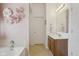 Bright bathroom with a tub, wooden vanity and pink accents at 6622 W Dickens Xing, McCordsville, IN 46055