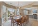 Sunlit dining area featuring a large wooden table, access to the backyard patio, and stylish decor at 6622 W Dickens Xing, McCordsville, IN 46055