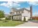 Angle view of the home showcasing the attached two-car garage, brick chimney, and well-kept lawn at 6622 W Dickens Xing, McCordsville, IN 46055