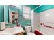 Bright turquoise bathroom with a shower-tub, decorative mirror, and window with white blinds at 6816 Minnow Dr, Indianapolis, IN 46237