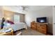 Carpeted bedroom with a ceiling fan, a TV on a dresser, and a comfortable single bed at 6816 Minnow Dr, Indianapolis, IN 46237